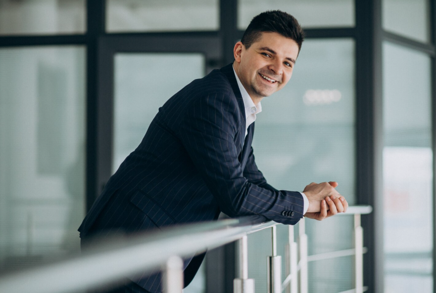 Professional smiling in an office while reflecting on what does success mean today beyond status and money.
