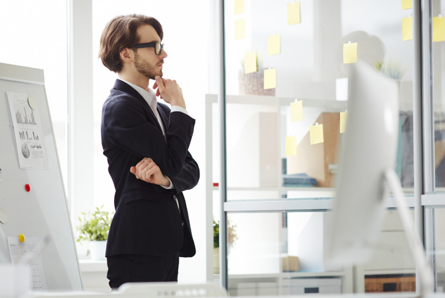 Professional reviewing sticky notes while learning how to make decisions when unsure.