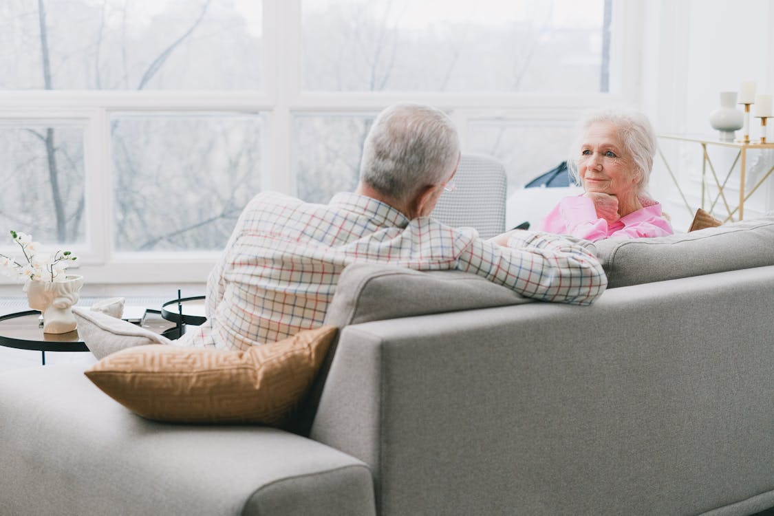 Older couple talking at home showing what makes a relationship last through trust and commitment.