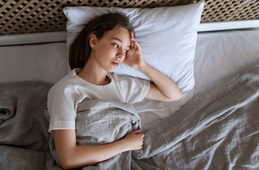 Person lying awake in bed wondering why do I overthink everything at night.