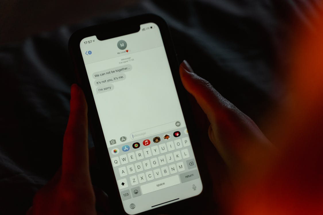Person reading a difficult text message while wondering why do people ghost instead of communicating.