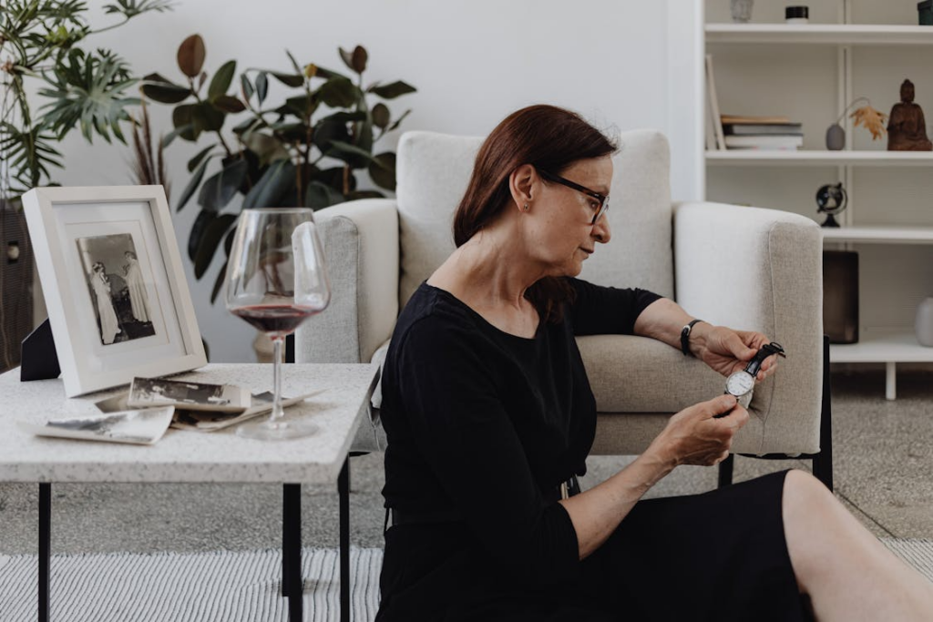 woman holding a watch near old photos showing why time feels faster as you get older