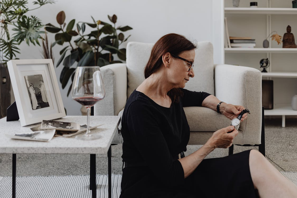 woman holding a watch near old photos showing why time feels faster as you get older